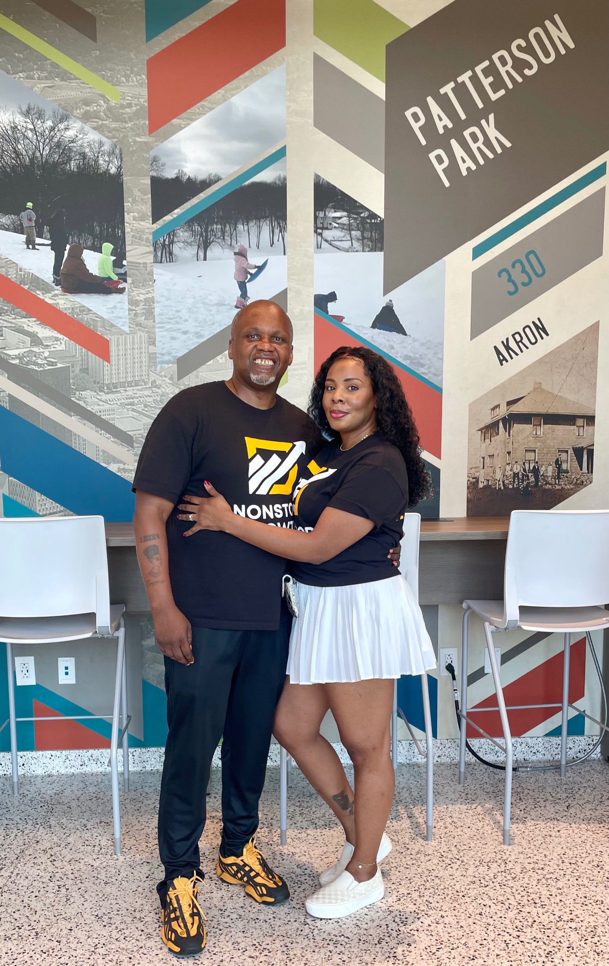 Marcel and Mia McDaniel standing together in front of a Patterson Park mural in Akron, Ohio.